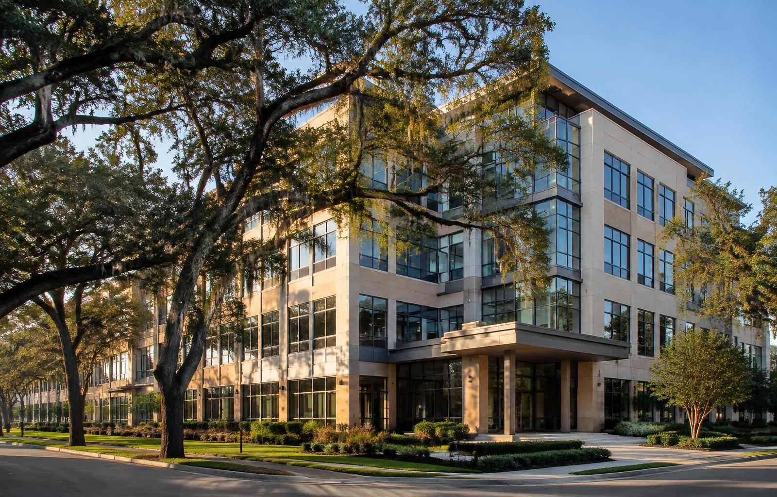 Commercial office building framed by live oak trees in Lafayette, Louisiana