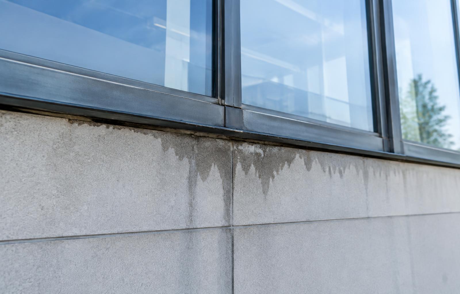 Water staining below a window frame on a commercial building facade in Lafayette, Louisiana